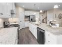 Open kitchen with stainless steel appliances, granite countertops, a center island, and dark wood flooring at 816 Walker Ridge Way, Willow Springs, NC 27592
