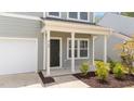 Close up of the front entrance featuring a black door, white columns, and manicured landscaping at 908 Adelphia Rd, Fuquay Varina, NC 27526