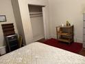 Bedroom with a closet and a small wooden table with flowers. The floor is covered in red carpet at 911 Holloway St, Durham, NC 27701
