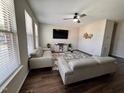 Bright living room with hardwood floors, modern furniture, a ceiling fan, and large windows for natural light at 1005 Lathrop Ln, Apex, NC 27523