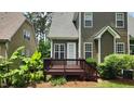 Wooden deck with stairs, surrounded by lush greenery and landscaping in the backyard at 1016 Dotson Way, Apex, NC 27523