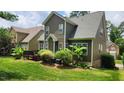 Exterior view of the home, showcasing the siding, deck, and well-maintained lawn with lush landscaping at 1016 Dotson Way, Apex, NC 27523