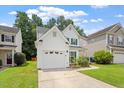 Charming home with a two-car garage, landscaped front yard, and sidewalk leading to the entrance at 1016 Goldmist Ln, Durham, NC 27713