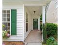 Inviting front porch with green door, adorned with a wreath, and lush green shrubbery at 1016 Goldmist Ln, Durham, NC 27713