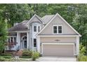 Inviting home exterior showcasing a two-car garage, manicured lawn, and elegant architectural details at 105 Gorge Ct, Cary, NC 27518