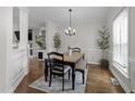 Dining room featuring wood floors, wainscoting, modern chandelier, and decorative houseplants at 105 Mcnaughton Ct, Garner, NC 27529