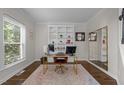Bright home office featuring a large window, custom built-ins, and elegant hardwood floors at 105 Mcnaughton Ct, Garner, NC 27529