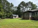 Spacious backyard featuring a storage shed and a partial view of the house at 105 Perry Ln, Zebulon, NC 27597