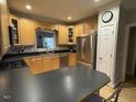 Well-lit kitchen featuring stainless steel appliances and sleek black countertops at 105 Perry Ln, Zebulon, NC 27597