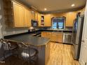 Traditional kitchen features light wood cabinetry, stainless steel appliances, and breakfast bar with seating at 105 Perry Ln, Zebulon, NC 27597