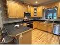 Well-lit kitchen with wooden cabinets, black countertops and stainless steel appliances at 105 Perry Ln, Zebulon, NC 27597