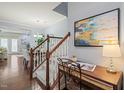 Open entryway with hardwood floors, white staircase, and a desk area, leading to the dining room at 108 Hundred Oaks Ln, Holly Springs, NC 27540