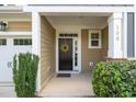 Inviting front entry featuring a dark door, wreath, covered porch, and well-maintained landscaping at 108 Hundred Oaks Ln, Holly Springs, NC 27540