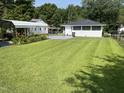 Spacious backyard with lush green grass and a convenient carport at 129 S Bullock St, Henderson, NC 27536