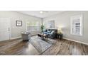 Comfortable living room with hardwood floors, gray sofa, decorative pillows, and window with blinds at 1625 Main Divide Dr, Wake Forest, NC 27587