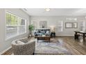 Bright living room featuring hardwood floors, a cozy couch, area rug, and sunlit windows at 1625 Main Divide Dr, Wake Forest, NC 27587