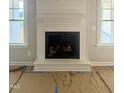 Close-up of a contemporary fireplace with white mantel, flanked by bright windows at 168 Clayton Rd, Princeton, NC 27569