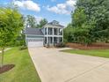 Beautiful blue two story home featuring a long driveway and well maintained lawn at 1804 Amberly Ledge Way, Cary, NC 27519