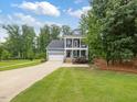 Beautiful blue two story home featuring a long driveway and well maintained lawn at 1804 Amberly Ledge Way, Cary, NC 27519