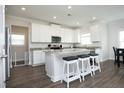 Bright kitchen featuring a granite island with seating, stainless appliances, and all-white cabinetry at 200 Sweet Violet Dr, Youngsville, NC 27596
