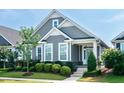 Charming home features a landscaped front yard, gray siding, and a welcoming turquoise front door at 209 Stone River Dr, Wendell, NC 27591