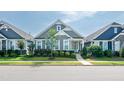 Charming home features a landscaped front yard, gray siding, and a welcoming turquoise front door at 209 Stone River Dr, Wendell, NC 27591