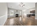 Spacious living room featuring hardwood floors, vaulted ceiling, fan, and cozy fireplace at 241 Fox Run, Benson, NC 27504