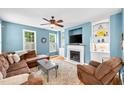 Comfortable living room with a fireplace, large windows, and stylish decor create a cozy atmosphere at 2445 Sapphire Valley Dr, Raleigh, NC 27604