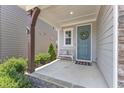 Inviting front porch with a seating bench, wreath-adorned blue door, and stone accents at 2969 Thirlestane Dr, Apex, NC 27502