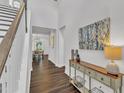Bright hallway with hardwood floors, neutral walls, and decorative console table at 2969 Thirlestane Dr, Apex, NC 27502