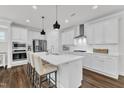 Modern kitchen features white cabinets, stainless steel appliances, a center island with seating, and pendant lights at 2969 Thirlestane Dr, Apex, NC 27502