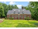 Beautiful brick home featuring dormer windows and manicured landscaping at 305 Lochridge Dr, Roxboro, NC 27573