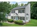 Well-maintained home with a garage, blue door, black shutters, and manicured landscaping at 3110 Trinness Dr, Durham, NC 27707