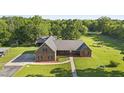Aerial view of a charming brick home with a large yard, mature trees, and outbuildings on a beautiful property at 3537 Sweetgum Rd, Gibsonville, NC 27249