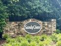 Stone sign showcasing the Sandy Chase community, surrounded by greenery at 3833 Hidden Branches Dr, Raleigh, NC 27613