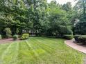Well-manicured backyard with lush lawn and mature trees, offering a private outdoor space at 5005 Lenoraway Dr, Raleigh, NC 27613
