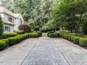 Long driveway framed by manicured landscaping, leading to a distinguished home at 5005 Lenoraway Dr, Raleigh, NC 27613