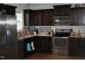 Modern kitchen featuring stainless steel appliances, dark wood cabinets, and stylish backsplash at 503 N Franklin Dr, Sanford, NC 27330