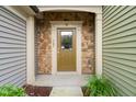A well-lit entryway with a stylish front door, stone accents, and verdant greenery at 507 Brier Crossings Loop, Durham, NC 27703
