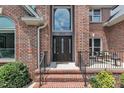 Elegant brick home featuring a beautiful front door and meticulously maintained landscaping at 5309 Overtop Ln, Raleigh, NC 27613