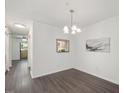 Bright dining room with modern light fixture and stylish gray wood-look flooring at 600 Audubon Lake Dr # 4B11, Durham, NC 27713