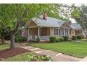 A charming home with a well-manicured lawn, inviting porch, and beautiful landscaping at 601 E Franklin St, Raleigh, NC 27604