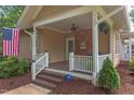 Inviting porch with a ceiling fan, brick accent wall, and outdoor seating area at 601 E Franklin St, Raleigh, NC 27604