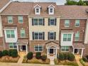 Brick townhome with dormer windows and covered entryway, complemented by manicured landscaping at 6027 Kentworth Drive. Dr, Holly Springs, NC 27540