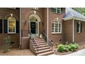 Home's brick front entrance features a wreath and decorative plants and is inviting at 603 Edburton Ct, Hillsborough, NC 27278