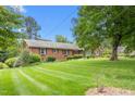 Well-maintained brick home with manicured lawn and mature trees at 619 S Fifth St, Mebane, NC 27302