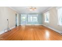 Bright living room with hardwood floors, neutral walls, and light blue accent wall at 619 S Fifth St, Mebane, NC 27302