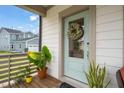 Charming front door with glass panel and a lovely wreath, enhanced by potted plants at 710 Vine Pkwy, Pittsboro, NC 27312