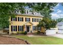 Charming yellow two-story home with black shutters, dormers, and manicured lawn at 1001 Kingsway Dr, Apex, NC 27502