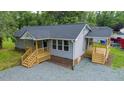 Gray home featuring a well-maintained exterior, wooden porches, and landscaped surroundings at 1006 S Second Ave Ave, Siler City, NC 27344